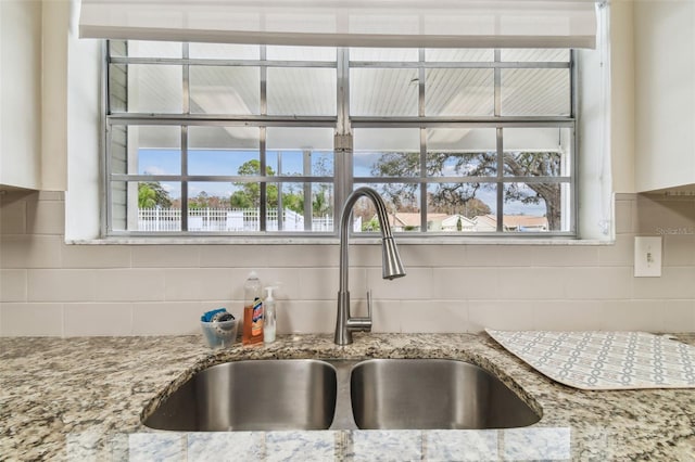 13127 Topflite Ct, Hudson, FL 34669 - kitchen view of a sink, backsplash, and light stone counters