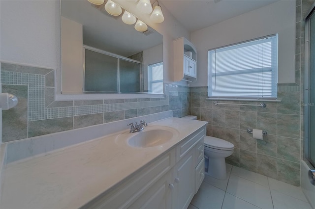 501 Poinsettia Rd, Belleair, FL 33756 - full bathroom featuring tile walls, vanity, a shower with door, tile patterned floors, and a wainscoted wall