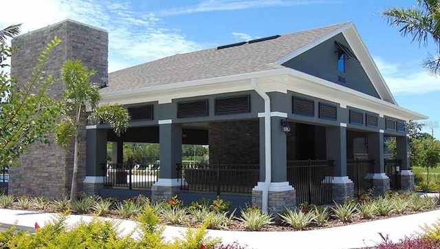 4444 Aqua Mirage St, Sarasota, FL 34238 - rear view of property with a porch, a chimney, roof with shingles, and stucco siding