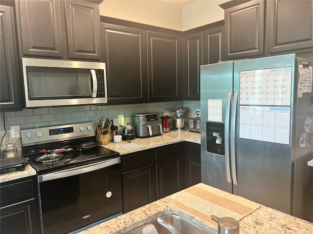 4444 Aqua Mirage St, Sarasota, FL 34238 - kitchen featuring stainless steel appliances, tasteful backsplash, and light stone countertops