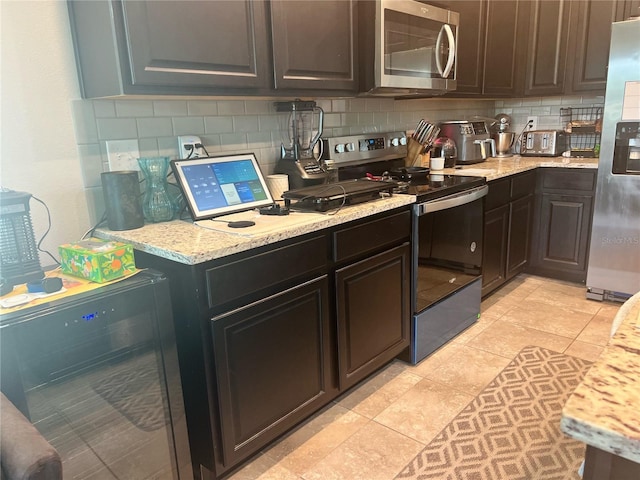 4444 Aqua Mirage St, Sarasota, FL 34238 - kitchen featuring stainless steel appliances, decorative backsplash, light stone countertops, beverage cooler, and dark brown cabinetry