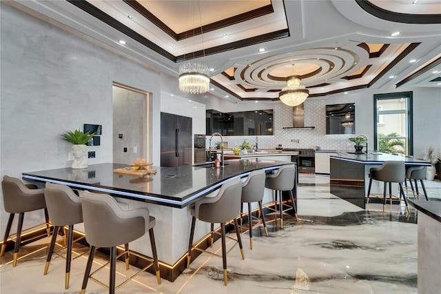 6526 Surfside Blvd, Apollo Beach, FL 33572 - kitchen featuring ornamental molding, high end refrigerator, dark countertops, a tray ceiling, and a breakfast bar