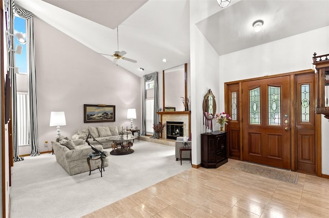 3133 Harvest Moon Dr, Palm Harbor, FL 34683 - foyer entrance with high vaulted ceiling, a glass covered fireplace, ceiling fan, and light carpet