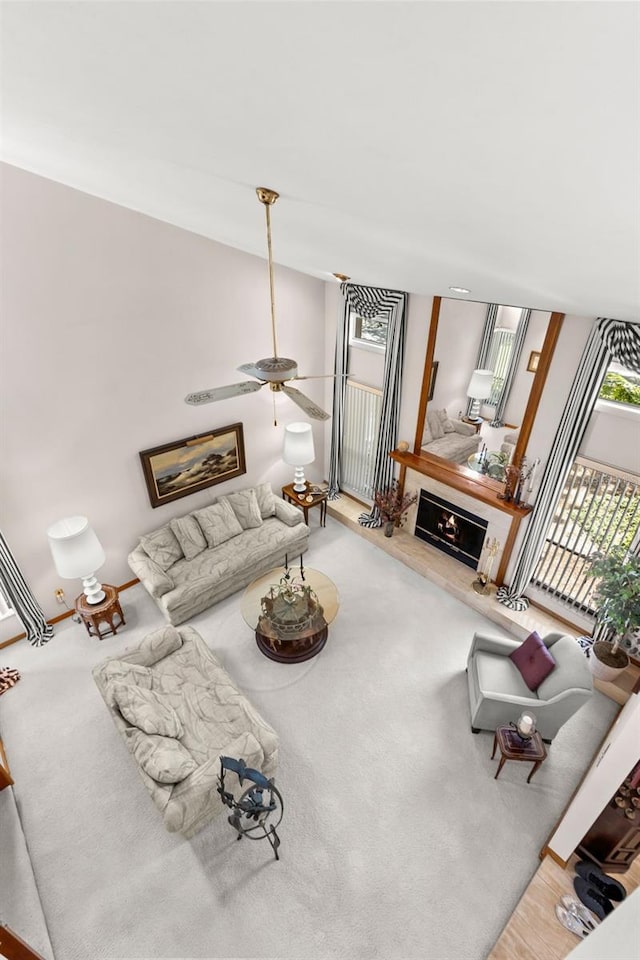 3133 Harvest Moon Dr, Palm Harbor, FL 34683 - living room with ceiling fan, a lit fireplace, and carpet floors