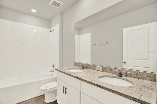 3146 Forrest Plum Ct, Zephyrhills, FL 33540 - bathroom with toilet, wood finished floors, double vanity, washtub / shower combination, and recessed lighting