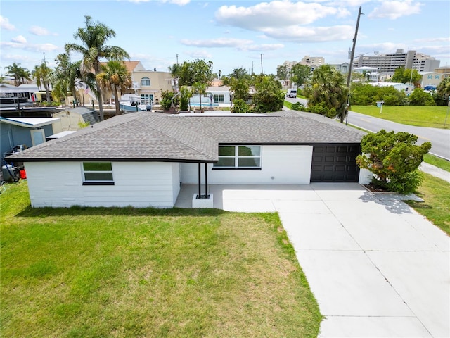 13715 Maria Dr, Hudson, FL 34667 - view of front of house with a shingled roof, concrete driveway, a front lawn, a garage, and a residential view