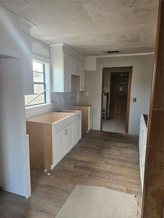 1011 Mallow Way, Brandon, FL 33510 - kitchen with wood finished floors, a textured ceiling, and white cabinets