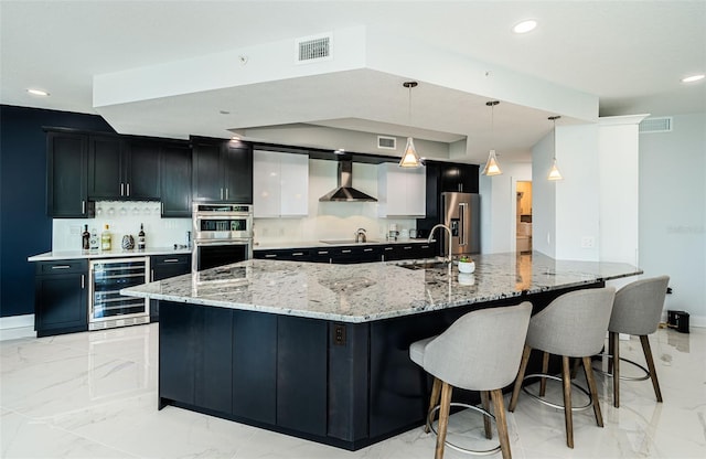 1 Seaside Ln Unit 302, Belleair, FL 33756 - kitchen with wine cooler, wall chimney range hood, appliances with stainless steel finishes, light marble finish flooring, and decorative backsplash