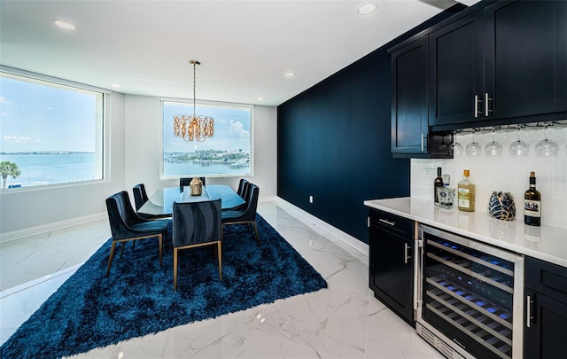 1 Seaside Ln Unit 302, Belleair, FL 33756 - dining space featuring beverage cooler, a bar, light marble finish flooring, a chandelier, and recessed lighting
