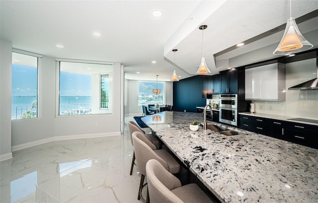 1 Seaside Ln Unit 302, Belleair, FL 33756 - kitchen with dark cabinetry, a breakfast bar area, double oven, healthy amount of natural light, and recessed lighting