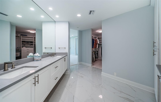 1 Seaside Ln Unit 302, Belleair, FL 33756 - bathroom with a walk in closet, double vanity, marble finish floors, and recessed lighting