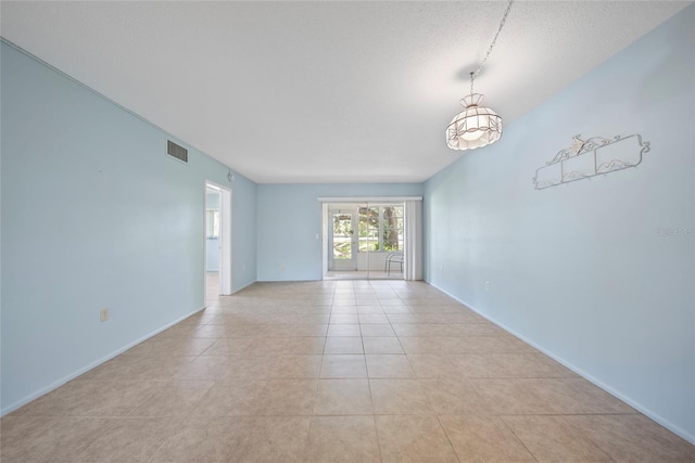 2003 Greenbriar Blvd Unit 1, Clearwater, FL 33763 - empty room featuring light tile patterned floors, a textured ceiling, and baseboards