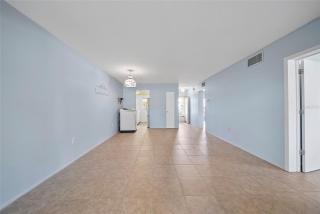 2003 Greenbriar Blvd Unit 1, Clearwater, FL 33763 - unfurnished living room featuring light tile patterned flooring, washer / dryer, and baseboards