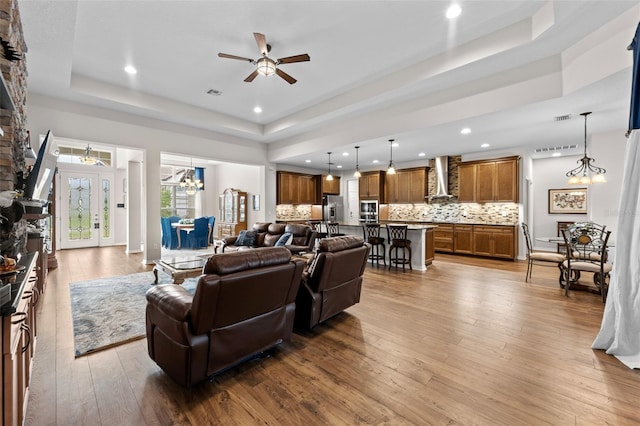 33219 Kateland Dr, Wesley Chapel, FL 33545 - living room featuring a tray ceiling, a ceiling fan, a chandelier, recessed lighting, and hardwood / wood-style floors