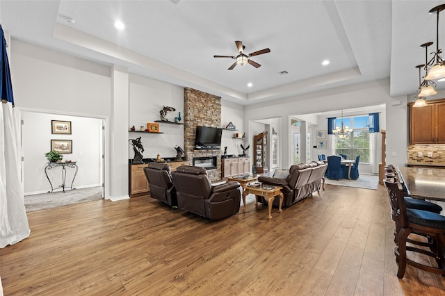 33219 Kateland Dr, Wesley Chapel, FL 33545 - living area featuring a tray ceiling, hardwood / wood-style floors, ceiling fan, a chandelier, and recessed lighting