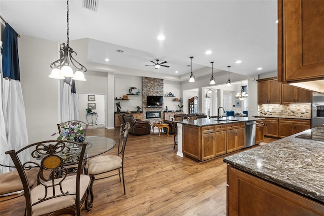 33219 Kateland Dr, Wesley Chapel, FL 33545 - kitchen with a ceiling fan, a sink, dishwasher, a fireplace, and light wood-type flooring