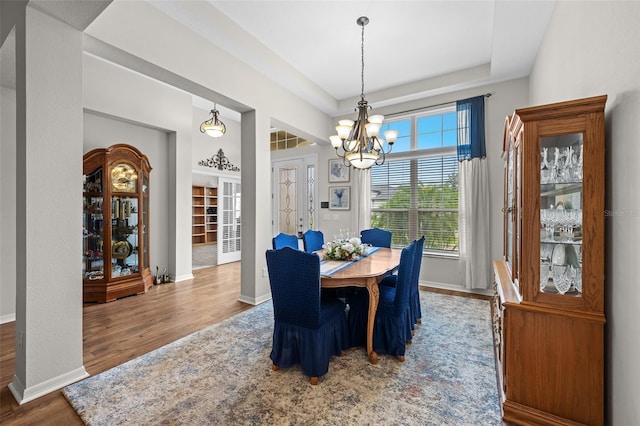 33219 Kateland Dr, Wesley Chapel, FL 33545 - dining area with a chandelier, wood finished floors, and baseboards