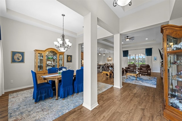 33219 Kateland Dr, Wesley Chapel, FL 33545 - dining room with a chandelier, a raised ceiling, wood finished floors, baseboards, and ceiling fan