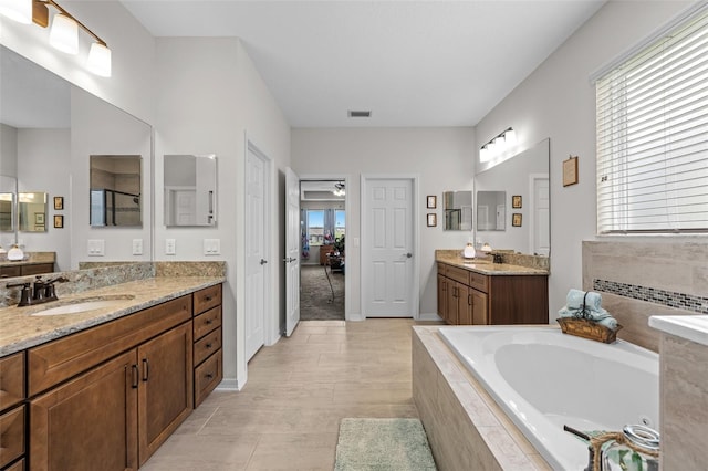 33219 Kateland Dr, Wesley Chapel, FL 33545 - full bath featuring a garden tub, two vanities, and baseboards