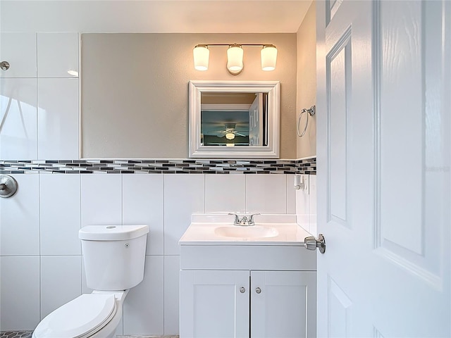 8329 Gulf Way, Hudson, FL 34667 - bathroom featuring vanity, tile walls, toilet, and ceiling fan