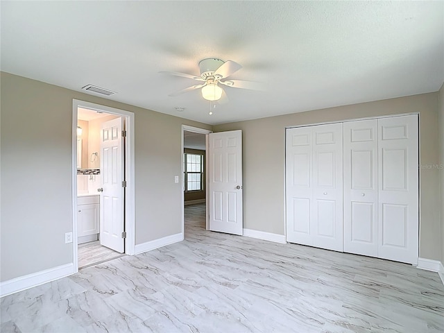 8329 Gulf Way, Hudson, FL 34667 - unfurnished bedroom featuring baseboards, light marble finish floors, a closet, a ceiling fan, and connected bathroom