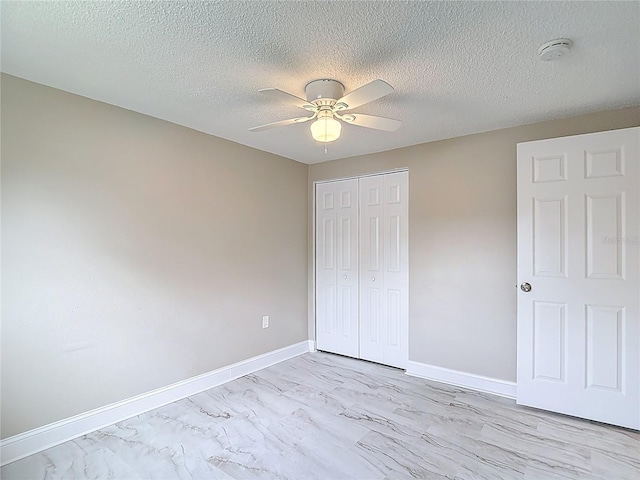 8329 Gulf Way, Hudson, FL 34667 - unfurnished bedroom featuring a closet, baseboards, a ceiling fan, and a textured ceiling