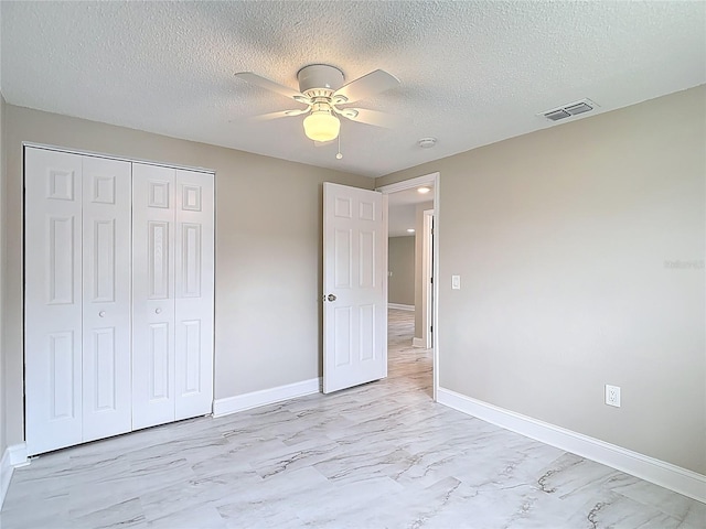 8329 Gulf Way, Hudson, FL 34667 - unfurnished bedroom featuring light marble finish flooring, baseboards, a closet, a textured ceiling, and a ceiling fan