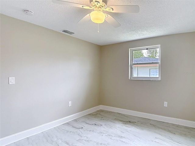 8329 Gulf Way, Hudson, FL 34667 - unfurnished room with a textured ceiling, marble finish flooring, a smoke detector, a ceiling fan, and baseboards