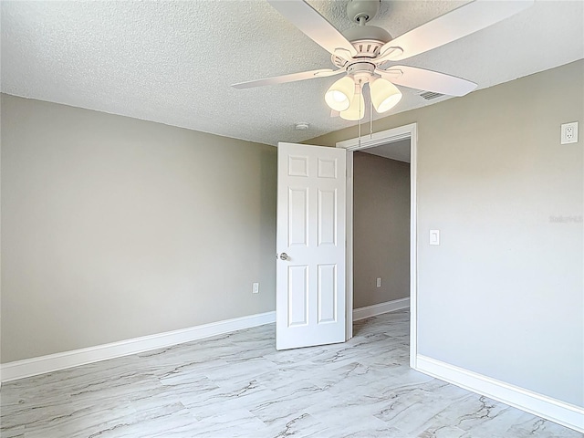 8329 Gulf Way, Hudson, FL 34667 - spare room featuring ceiling fan, light marble finish flooring, baseboards, and a textured ceiling