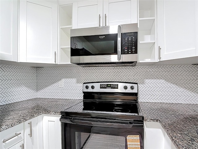 8329 Gulf Way, Hudson, FL 34667 - kitchen with stainless steel microwave, black / electric stove, open shelves, and white cabinetry
