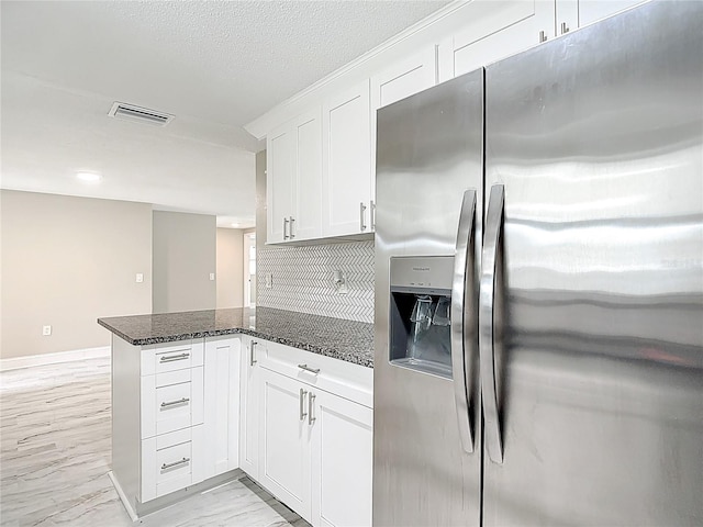 8329 Gulf Way, Hudson, FL 34667 - kitchen with stainless steel fridge with ice dispenser, a peninsula, white cabinets, dark stone countertops, and decorative backsplash