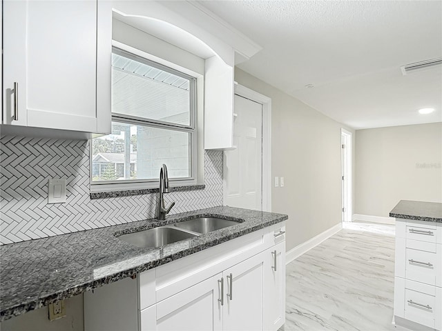 8329 Gulf Way, Hudson, FL 34667 - kitchen with a sink, backsplash, white cabinets, and dark stone counters