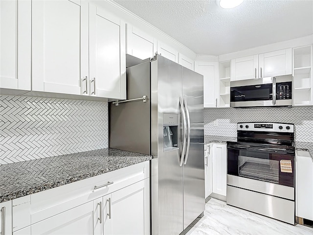 8329 Gulf Way, Hudson, FL 34667 - kitchen with appliances with stainless steel finishes, open shelves, white cabinets, dark stone counters, and decorative backsplash