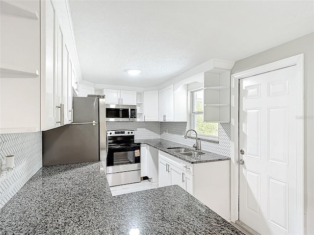 8329 Gulf Way, Hudson, FL 34667 - kitchen with open shelves, stainless steel appliances, a sink, dark stone countertops, and white cabinets