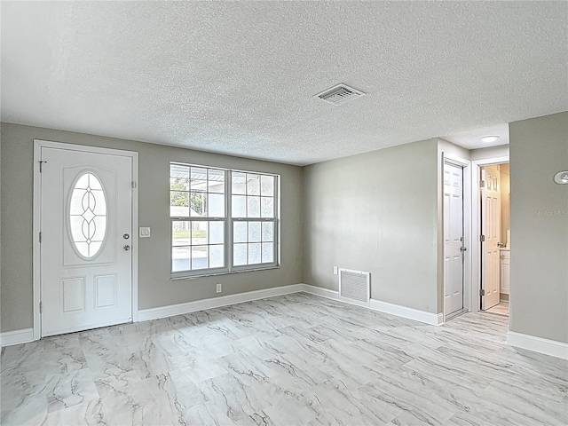8329 Gulf Way, Hudson, FL 34667 - foyer with light marble finish flooring, baseboards, and a textured ceiling
