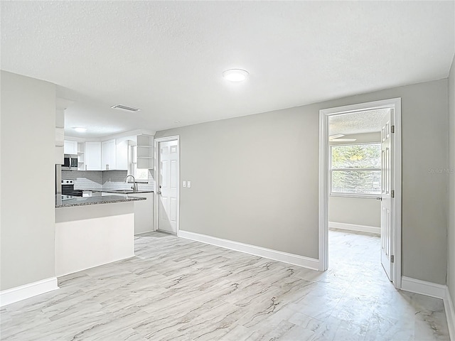 8329 Gulf Way, Hudson, FL 34667 - kitchen with a sink, white cabinetry, baseboards, open shelves, and tasteful backsplash
