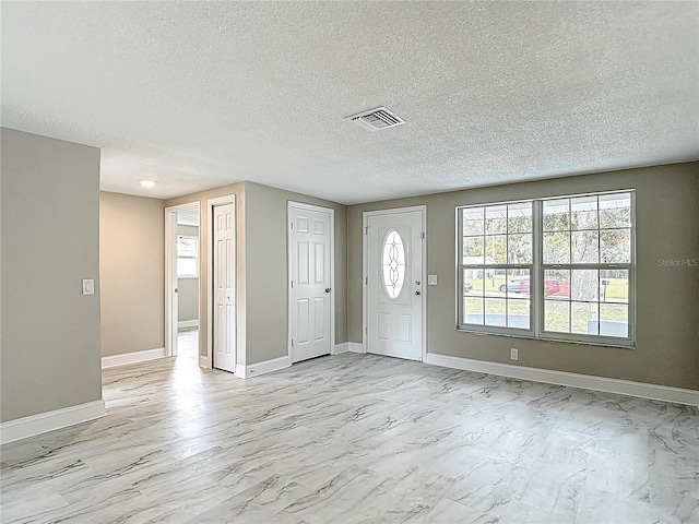 8329 Gulf Way, Hudson, FL 34667 - foyer entrance with baseboards, a textured ceiling, and light marble finish floors