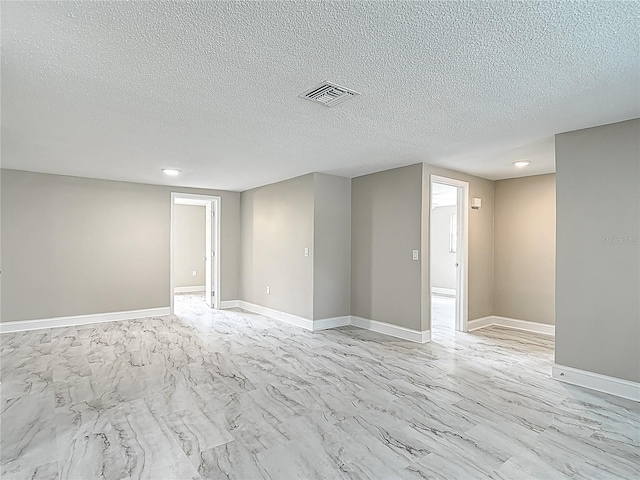 8329 Gulf Way, Hudson, FL 34667 - empty room featuring a textured ceiling, baseboards, and light marble finish flooring
