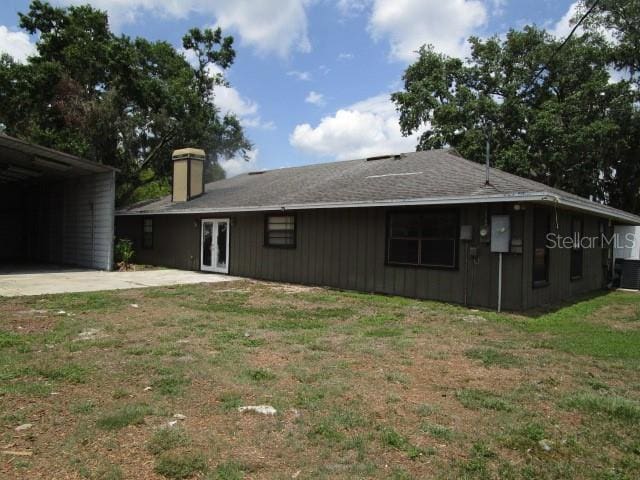 5190 Starling Dr, Mulberry, FL 33860 - view of home's exterior featuring a lawn, a chimney, and french doors