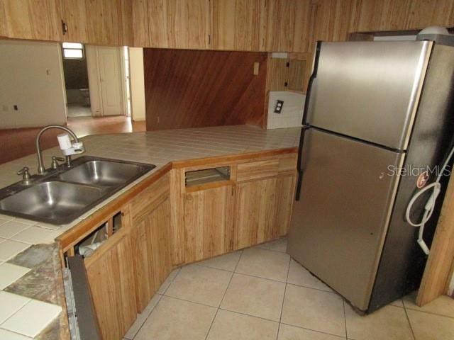 5190 Starling Dr, Mulberry, FL 33860 - kitchen with freestanding refrigerator, tile countertops, light tile patterned flooring, and a peninsula