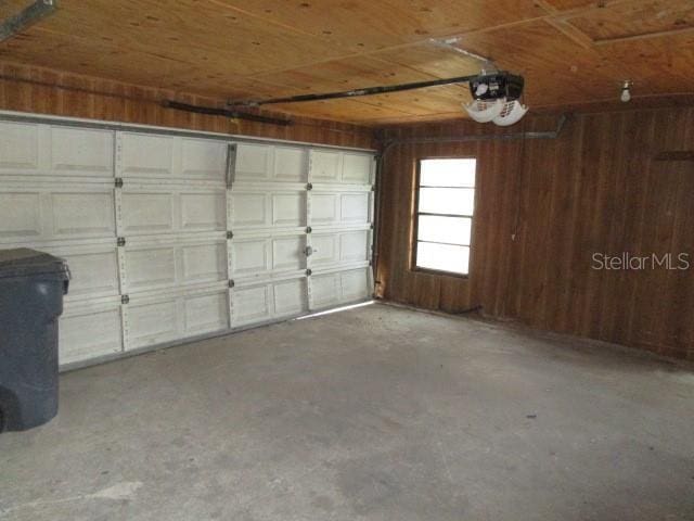 5190 Starling Dr, Mulberry, FL 33860 - garage featuring a garage door opener, wood walls, and wooden ceiling