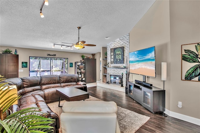 12219 Steppingstone Blvd, Tampa, FL 33635 - living area featuring rail lighting, baseboards, ceiling fan, dark wood finished floors, and a stone fireplace