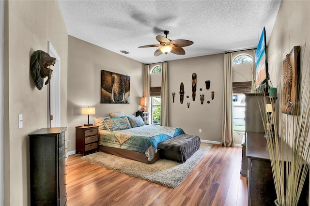 12219 Steppingstone Blvd, Tampa, FL 33635 - bedroom featuring light wood-type flooring, a textured ceiling, baseboards, and a ceiling fan