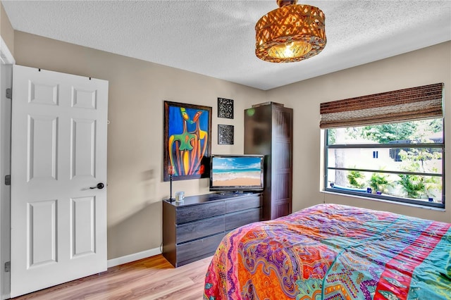 12219 Steppingstone Blvd, Tampa, FL 33635 - bedroom with light wood finished floors, a textured ceiling, and baseboards