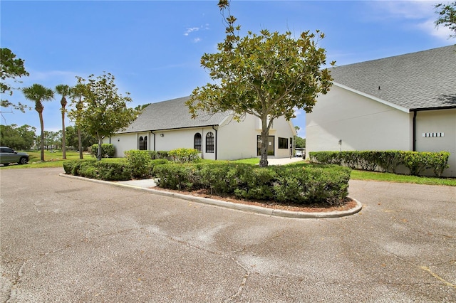 12219 Steppingstone Blvd, Tampa, FL 33635 - view of home's exterior with stucco siding and a shingled roof