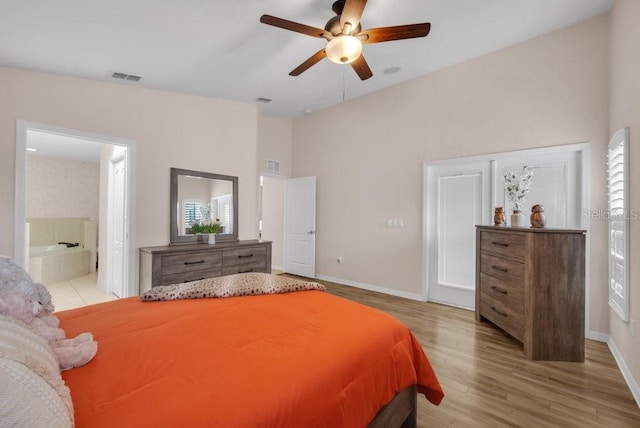 241 Royal Palm Way, Spring Hill, FL 34608 - bedroom featuring wood finished floors, a high ceiling, baseboards, connected bathroom, and ceiling fan