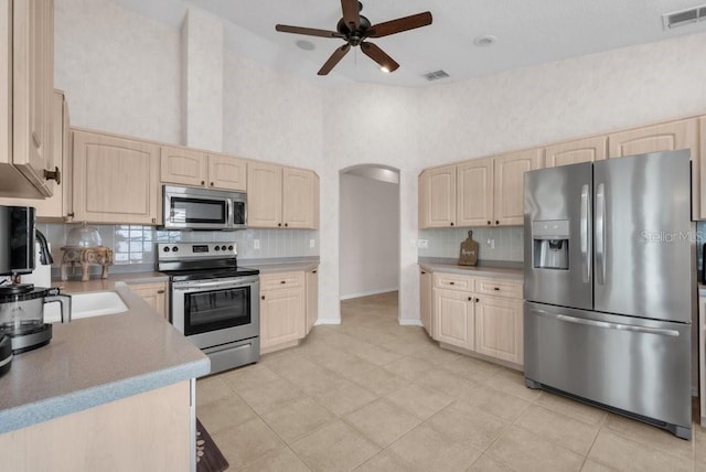 241 Royal Palm Way, Spring Hill, FL 34608 - kitchen with stainless steel appliances, light brown cabinetry, a towering ceiling, ceiling fan, and decorative backsplash