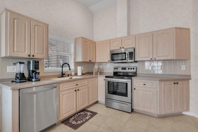 241 Royal Palm Way, Spring Hill, FL 34608 - kitchen featuring appliances with stainless steel finishes, a sink, light brown cabinetry, tasteful backsplash, and a high ceiling