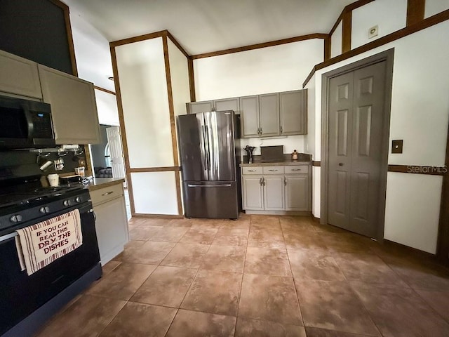 1716 Bondurant Way, Brandon, FL 33511 - kitchen with freestanding refrigerator, range with gas cooktop, black microwave, light tile patterned floors, and a high ceiling