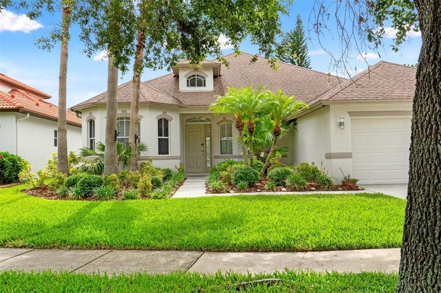 2238 Shirecrest Cove Way, Lutz, FL 33558 - view of front of home featuring stucco siding, an attached garage, a front yard, and roof with shingles